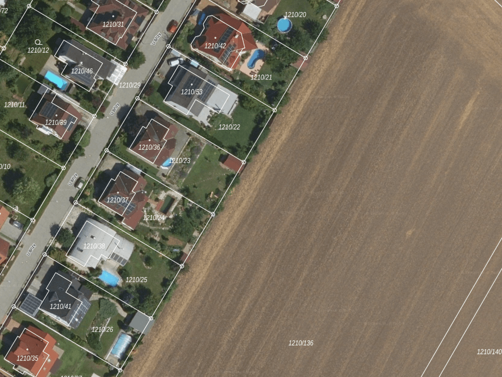 Pole obhospodařované až po hranici zahrad rodinných domů v satelitním městečku